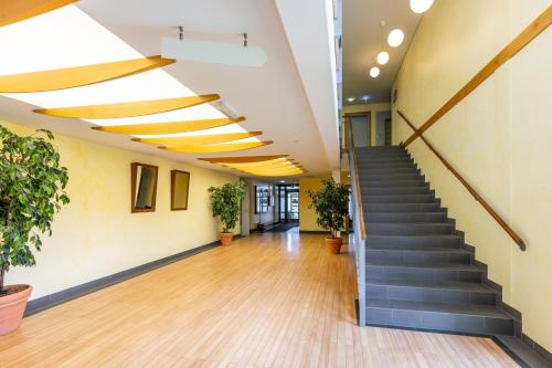 an office lobby with stairs and potted plants at Dresdner Tor Süd in Wilsdruff