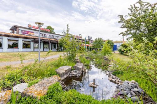 a garden with a pond in front of a building at Dresdner Tor Süd in Wilsdruff