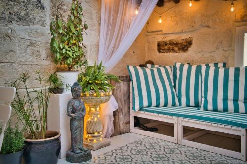 une terrasse couverte avec un canapé et des plantes en pot dans l'établissement Appartement-Terrasse Centre Historique, à Uzès