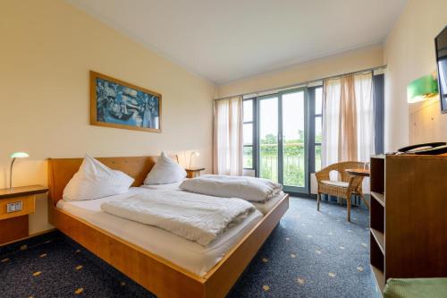 um quarto de hotel com uma cama e uma grande janela em Dresdner Tor Süd em Wilsdruff