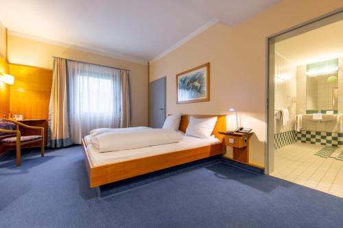 a hotel room with a bed and a bathroom at Dresdner Tor Süd in Wilsdruff