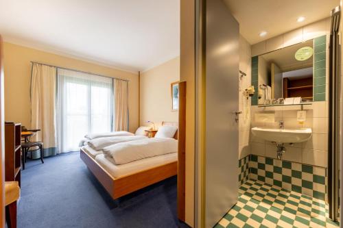 a bedroom with a bed and a sink and a mirror at Dresdner Tor Süd in Wilsdruff