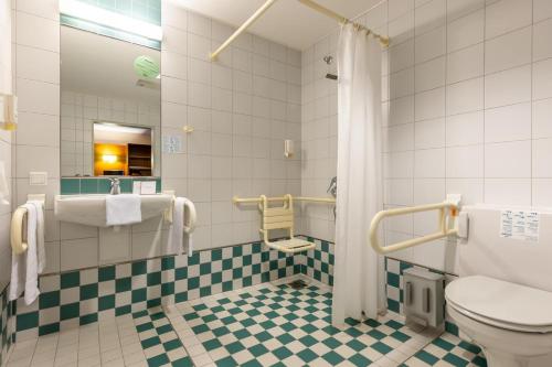 uma casa de banho com WC e azulejos verdes e brancos. em Dresdner Tor Süd em Wilsdruff