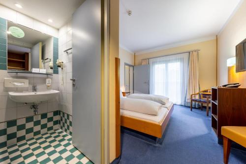 a bathroom with a bed and a sink in a room at Dresdner Tor Süd in Wilsdruff