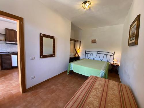 ポルトフェッラーイオにあるParco delle Ginestreのベッドルーム1室(ベッド1台、壁掛け鏡付)