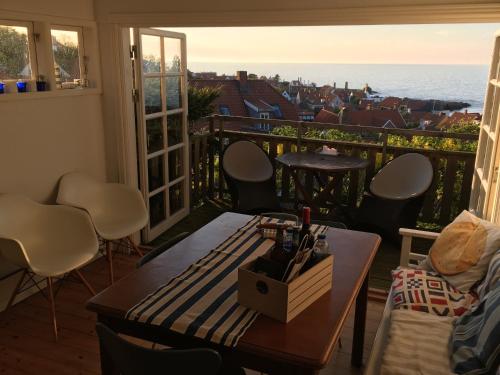 a balcony with a table and chairs and a view of the ocean at SPECTACULAR PANORAMIC VIEWS OF GUDHJEM in Gudhjem