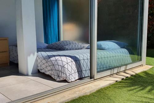 une chambre avec un lit à l'extérieur d'une fenêtre dans l'établissement Grand T2 60M² /Jardin 50M² plein sud /Mer à pieds, à Saint-Mandrier-sur-Mer