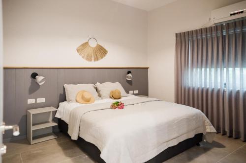 a bedroom with a large white bed with flowers on it at כפר הנופש קיבוץ גדות Kibbutz Gadot Galilean Resort in Gadot