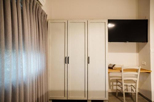 a white cabinet in a room with a table at כפר הנופש קיבוץ גדות Kibbutz Gadot Galilean Resort in Gadot