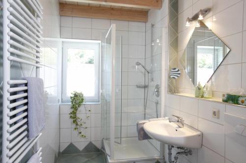a white bathroom with a sink and a shower at Ferienwohnungen Holder in Anhausen