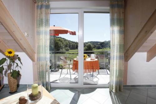 a room with a balcony with a table and an umbrella at Ferienwohnungen Holder in Anhausen