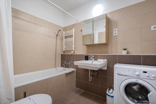 uma casa de banho com uma máquina de lavar roupa e um lavatório em White Cascade Realty Apartment em Budapeste