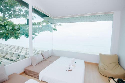 a living room with a couch and a large window at Amanda อามันดา in Ban Pak Ba Ra