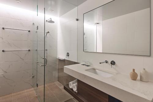 a bathroom with a sink and a glass shower at Rydges Perth Kings Square in Perth
