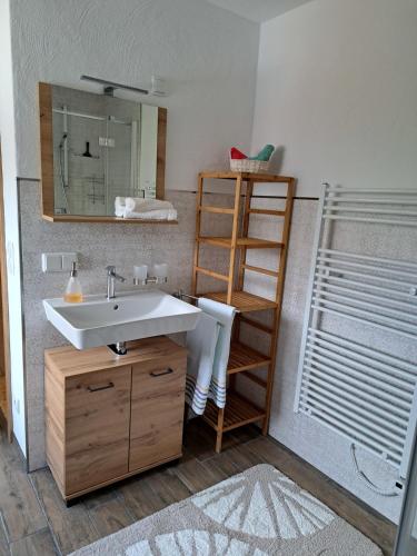 ein Badezimmer mit einem Waschbecken und einem Holzregal in der Unterkunft Fewo ,Sonnenstübchen, in Mendig