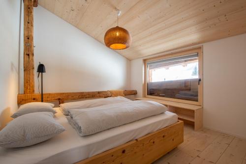 Schlafzimmer mit einem Bett und einem Fenster in der Unterkunft Stadel Jäger in Reckingen - Gluringen