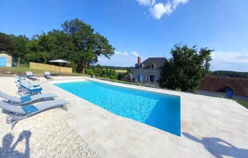 a swimming pool with chairs and a house at Villa du Cerf Thibault in Le Blanc