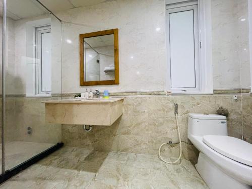 La salle de bains est pourvue de toilettes, d'un lavabo et d'un miroir. dans l'établissement Villa Lumina An Vien Nha Trang, à Nha Trang