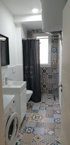 a bathroom with a black shower curtain and a toilet at Near beach apartment. in Golem