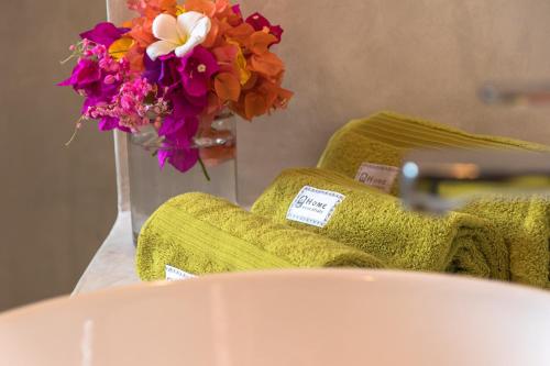 a vase of flowers sitting on a table with towels at Pingwe Beach Apartments in Pingwe
