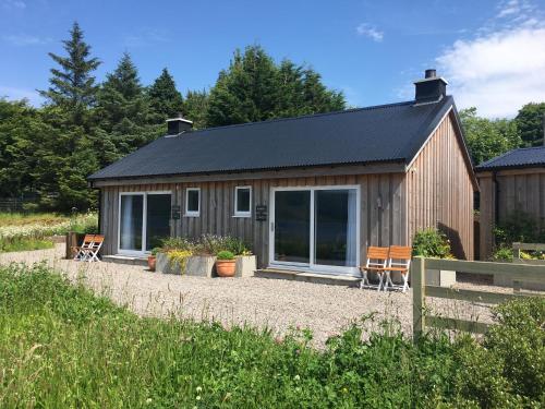 a small cabin with a solar roof and chairs at Kirkton Bay House Bed and Breakfast in Kyle of Lochalsh