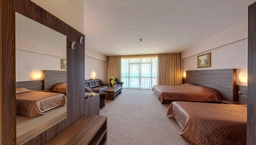 een hotelkamer met 2 bedden en een spiegel bij Elena Hotel and Wellness - All Inclusive in Goudstrand