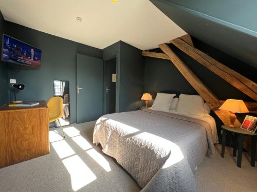 1 dormitorio con 1 cama grande en una habitación en Hôtel Le France en Aubusson