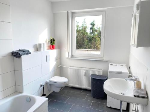 Baño blanco con aseo y lavamanos en Fully equipped Cozy Apartment en Hanau am Main