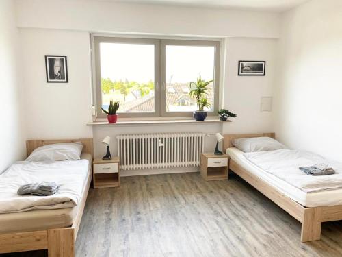 2 camas en una habitación con ventana en Fully equipped Cozy Apartment en Hanau am Main