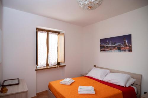 a bedroom with a bed with an orange blanket at alloggio del Viandante in Montefiascone