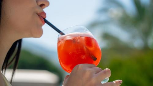 a woman drinking a drink with a straw at Salonika Suites in Oludeniz