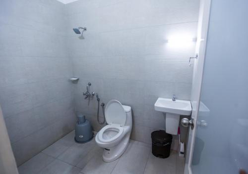 a white bathroom with a toilet and a sink at Mount Tales Vagamon in Vagamon