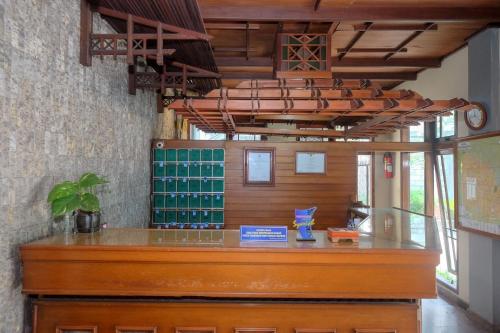 a bar with a wooden counter in a room at Urbanview Hotel Syariah Wisnugraha by RedDoorz in Yogyakarta