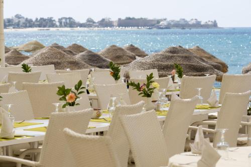 a table with white chairs on the beach at The Sindbad in Hammamet