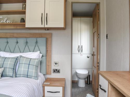 a bedroom with a bed and a toilet and cabinets at Lake View - Uk36811 in Whalley