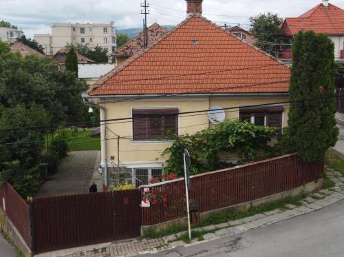 una casa con techo rojo y valla en Rózsa apartman en Odorheiu Secuiesc