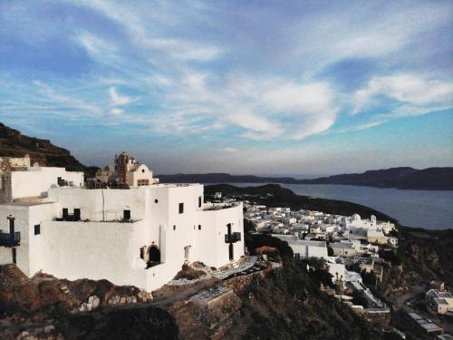 un edificio bianco in cima a una montagna di Castrum Traditional Sunset Suites a Plaka Milou