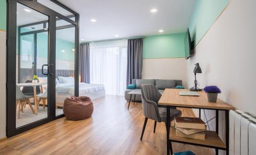 Una sala de estar con una mesa y una habitación con un sofá. en Kazbegi MaNa Apartment N 111, en Kazbegi