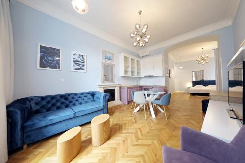 a living room with a blue couch and a table at Stay Swanky Bed & Breakfast in Zagreb