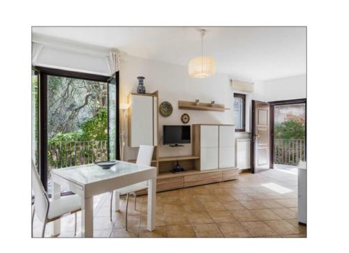a dining room with a white table and a television at PHS Panoramic House Suite in Taormina