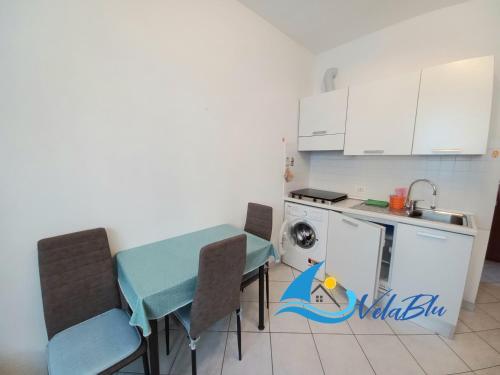 een kleine keuken met een tafel en stoelen in een kamer bij Casa Gino in San Bartolomeo al Mare