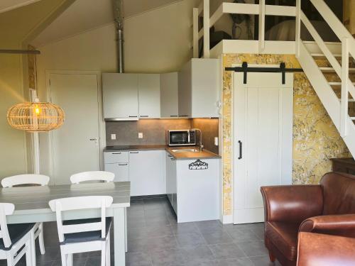 a kitchen with a table and a dining room at Doornvlak - dicht bij strand en duinen! in Castricum