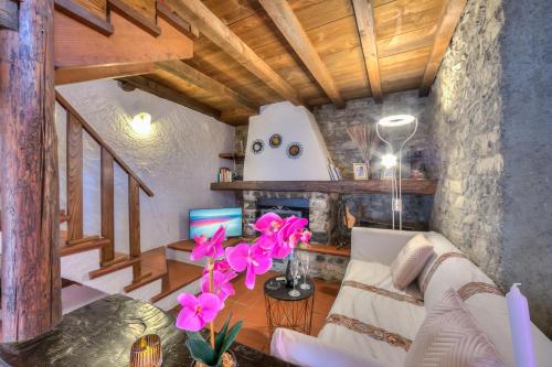 a living room with a white couch and pink flowers at Rustico Romantico Brè - Happy Rentals in Lugano