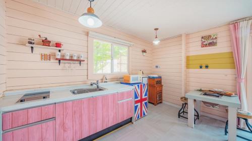 eine Küche mit holzgetäfelten Wänden und einer Arbeitsplatte in der Unterkunft Arasol Pension in Geoje
