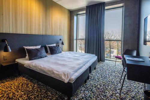 una camera con letto e scrivania di Peak 12 Hotel a Viborg