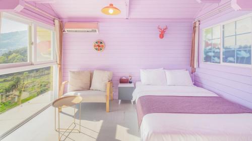 a purple room with two beds and a chair at Arasol Pension in Geoje 