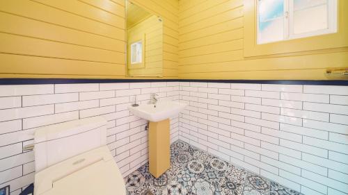 a bathroom with a sink and a toilet in it at Arasol Pension in Geoje 