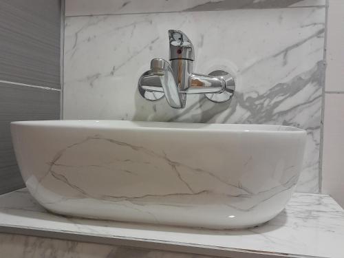 un lavandino bianco da bagno con rubinetto su un bancone di Apartmani Urlic a Sreser