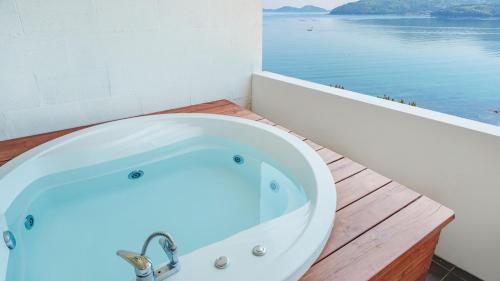a bath tub sitting on a wooden counter next to the water at Arasol Pension in Geoje 