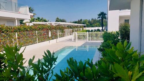 a swimming pool in front of a building at JESOLO GROUND FLOOR FLAT WITH POOL - 2 family apartments in Lido di Jesolo